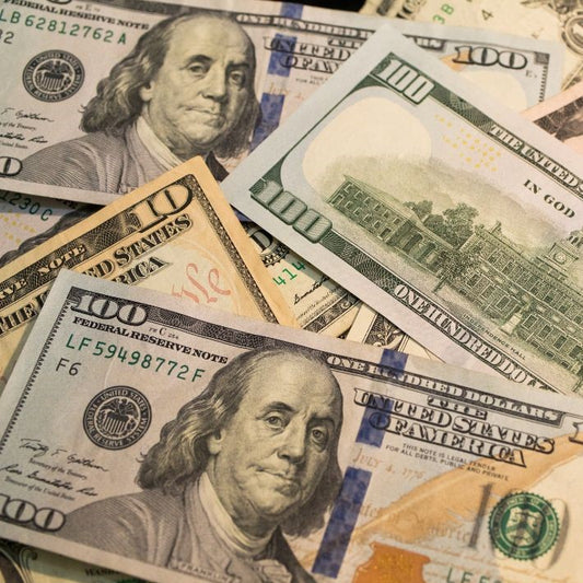 The images shows one hundred dollar bills and ten dollar bills loosely piled up, highlighting the cost of improving posture.
